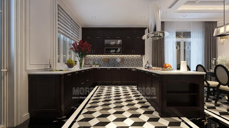 Hệ thống tủ bếp bằng gỗ tự nhiên màu đen kết hợp với màu trắng của tường nhà và kính ốp bếp mang lại một không gian nhà bếp sang chảnh. Đảo bếp được thiết kế như một chiếc bàn đa năng để giúp bà nội trợ thỏa thích trưng bày đồ ăn và thỏa sức trổ tài nội trợ. Tủ bếp gỗ, tủ bếp gỗ tự nhiên, tủ bếp tân cổ điển